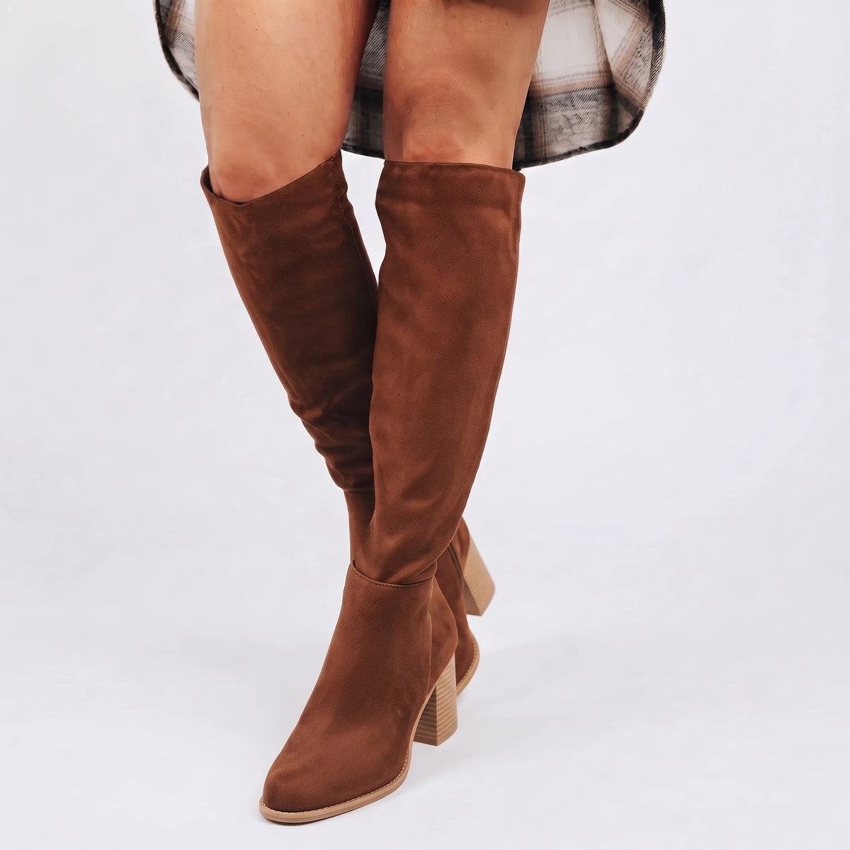 Marron paire de bottes hautes à talon bloc, portées avec une robe à motifs