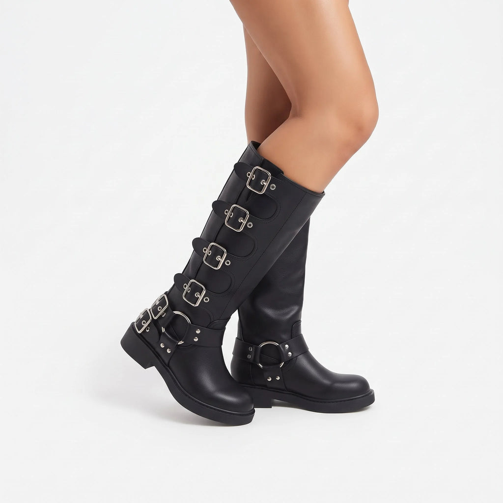 Noir botte femme portée au pied en marche, cinq sangles à boucles carrées et harnais de cheville à anneau métallique